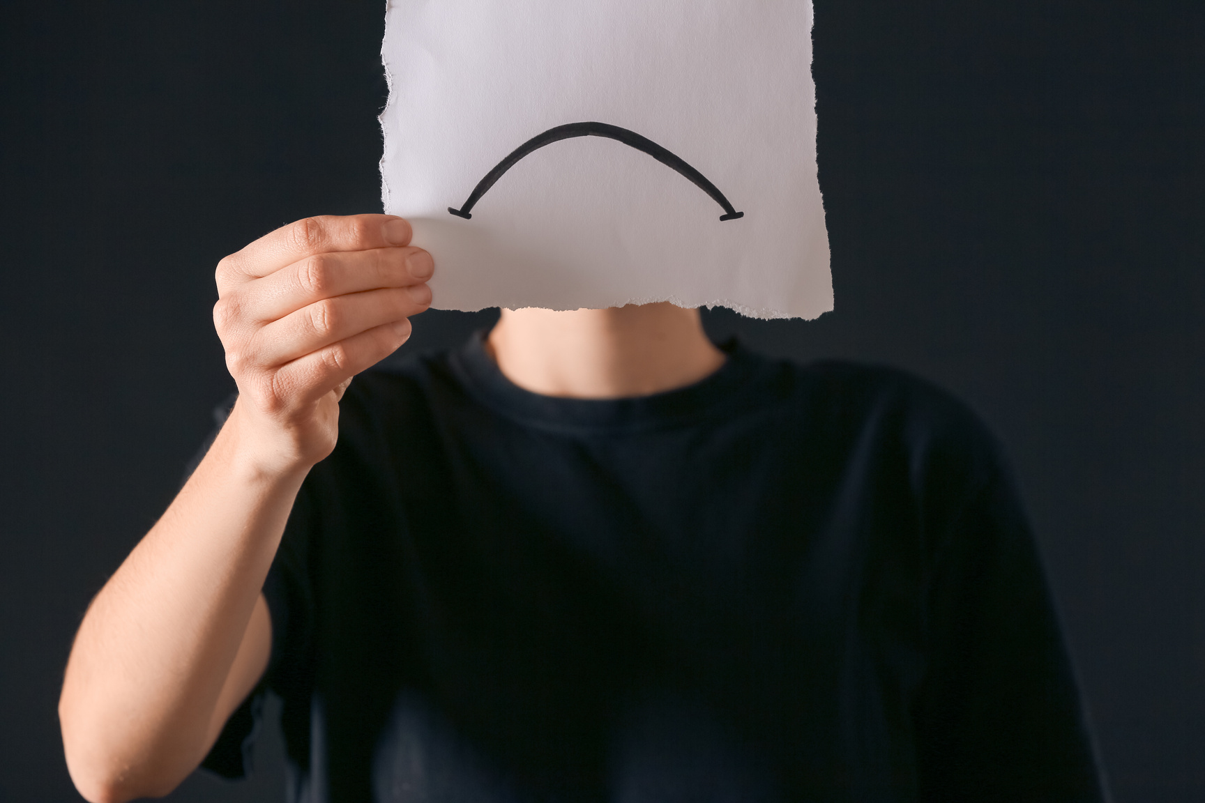 Person Holding Paper Sheet with Drawn Sad Mouth